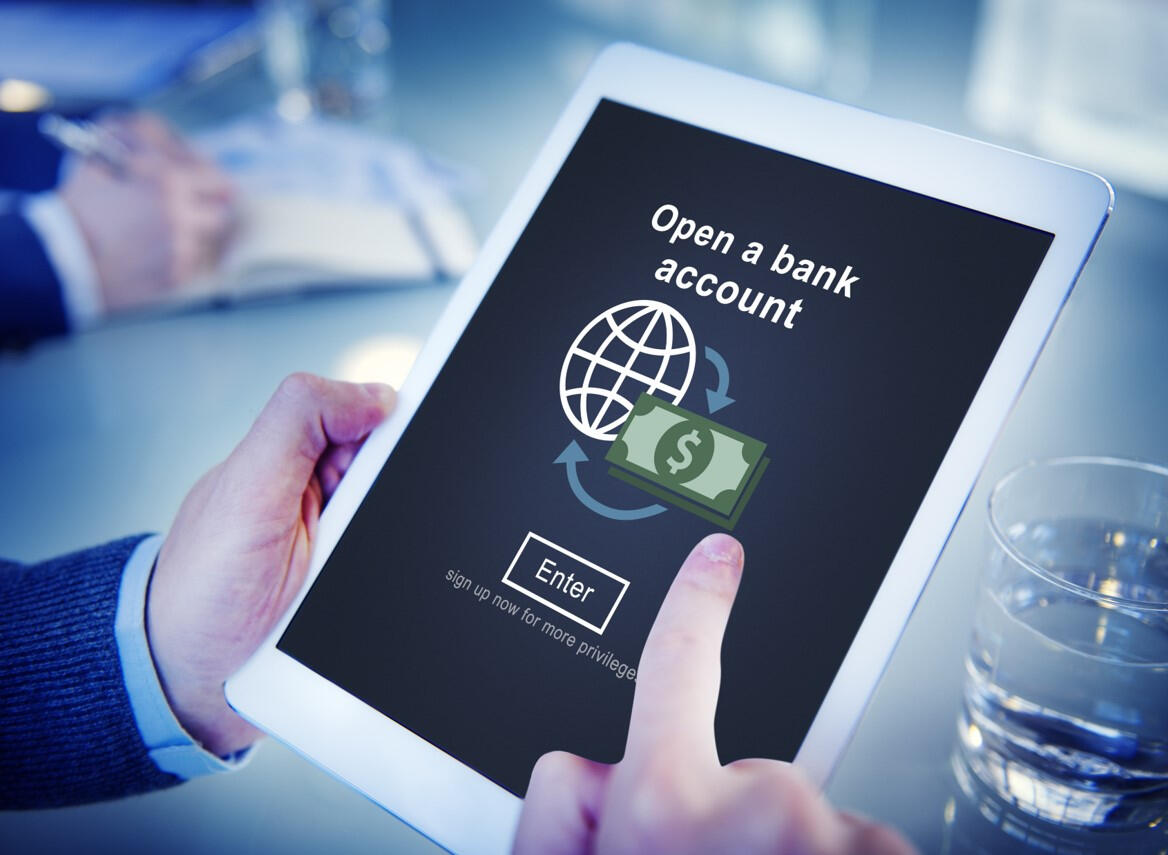 Hands holding an ipad with a message that says open a bank account and an enter button